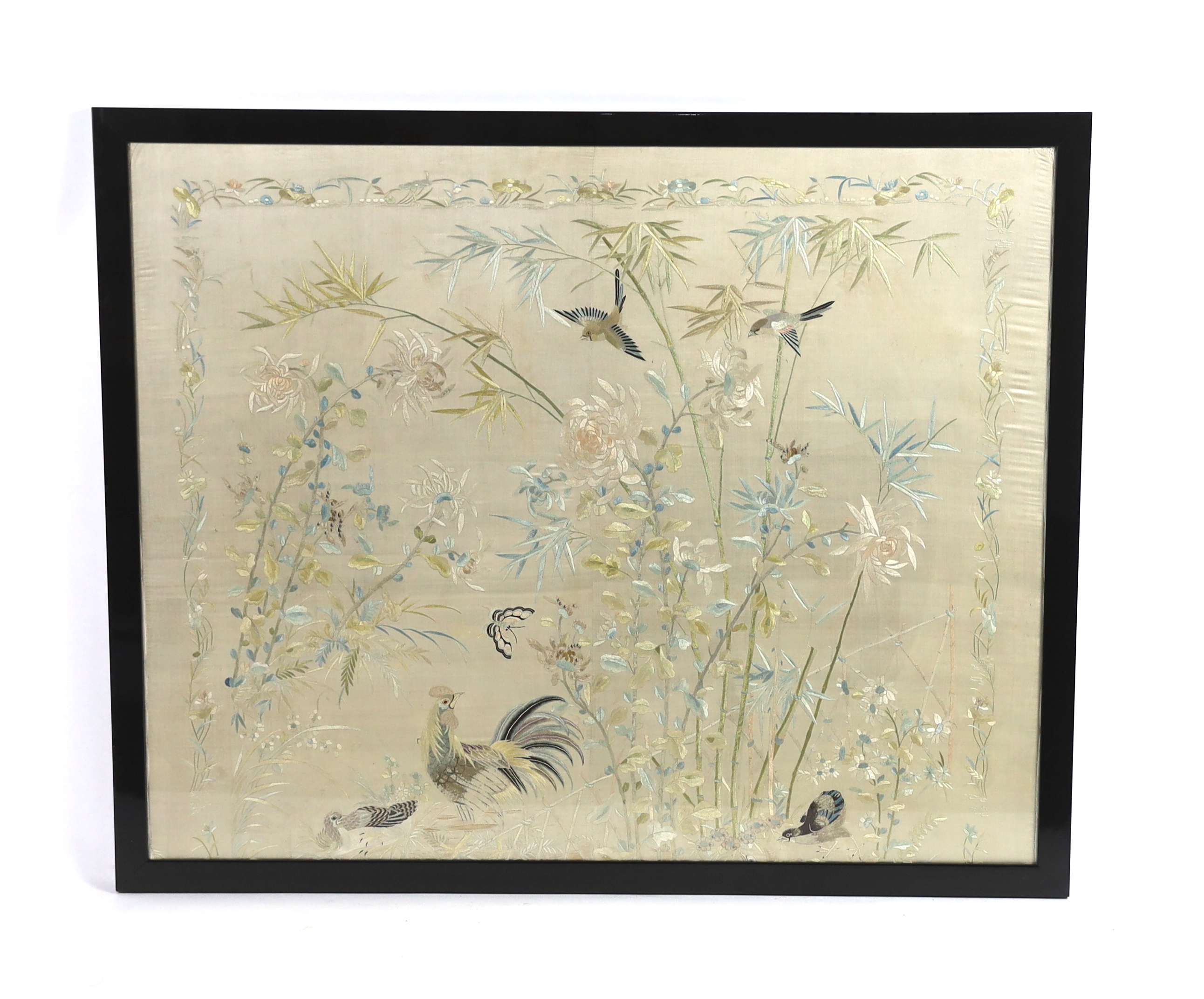 A framed early 20th century Chinese silk embroidered shawl, embroidered with chickens, ducks, flying birds and insects amongst bamboo and flowering plants, 126cm wide x 10.5cm high